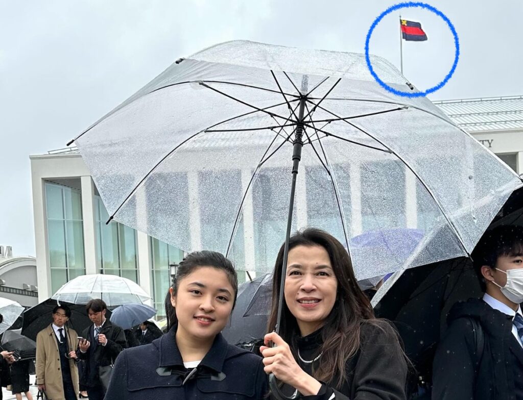 後ろに塾旗が写っている川井郁子と娘の画像